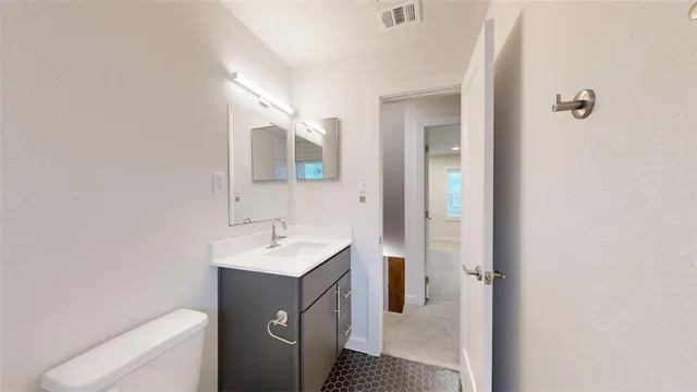 a bathroom with a sink toilet and mirror