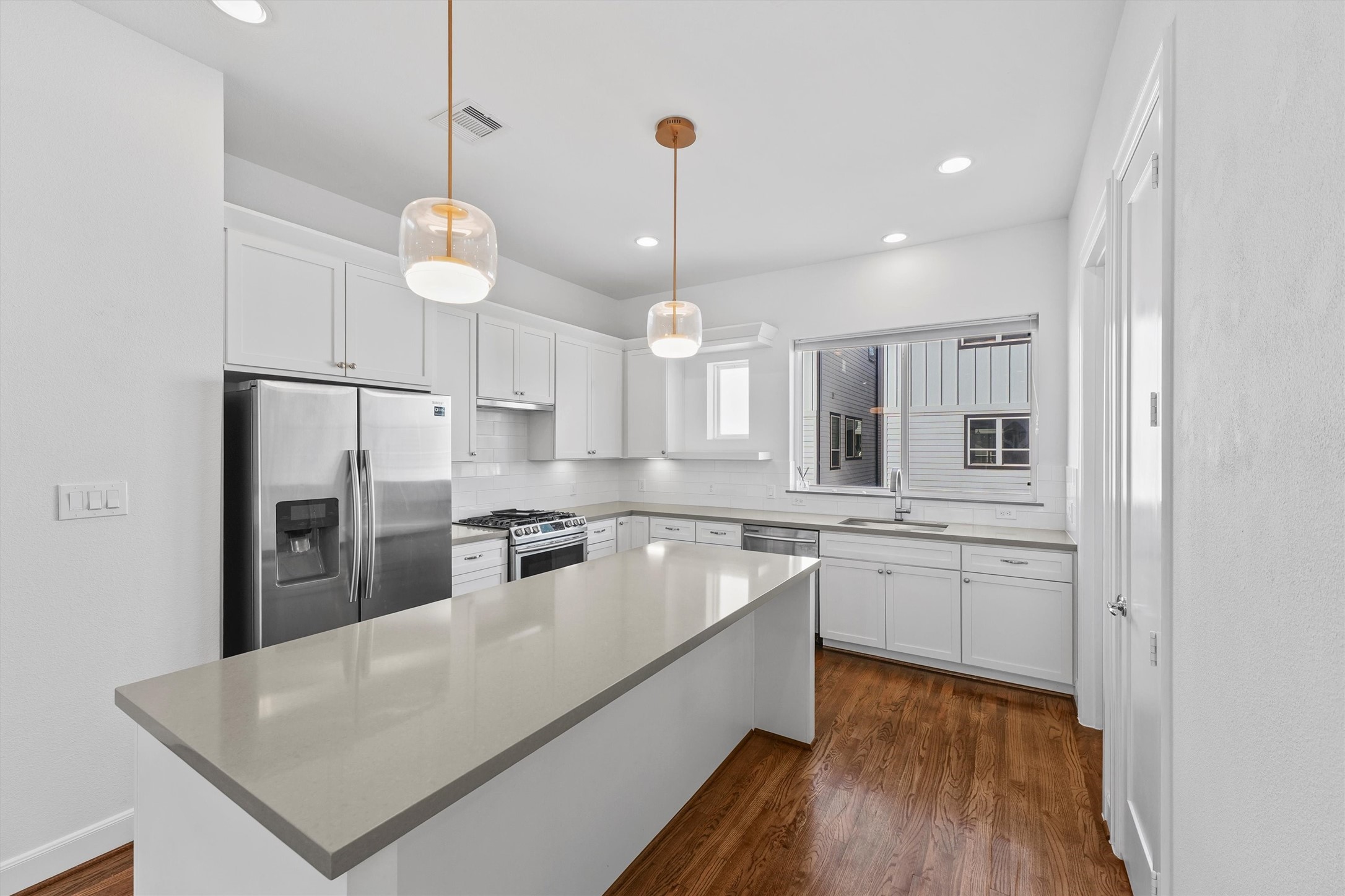 1050 Timbergrove Yards Lane Houston, TX 77008 - Photo 9 of 33 a large kitchen with stainless steel appliances granite countertop a sink a stove a refrigerator and a dining table with wooden floor