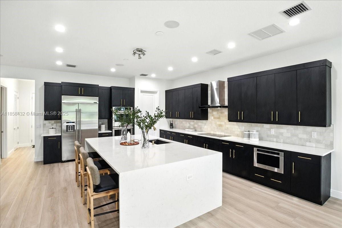 17819 Southwest 58th Street Southwest Ranches, FL 33331 - Photo 13 of 56 a kitchen with stainless steel appliances kitchen island granite countertop a sink and a refrigerator
