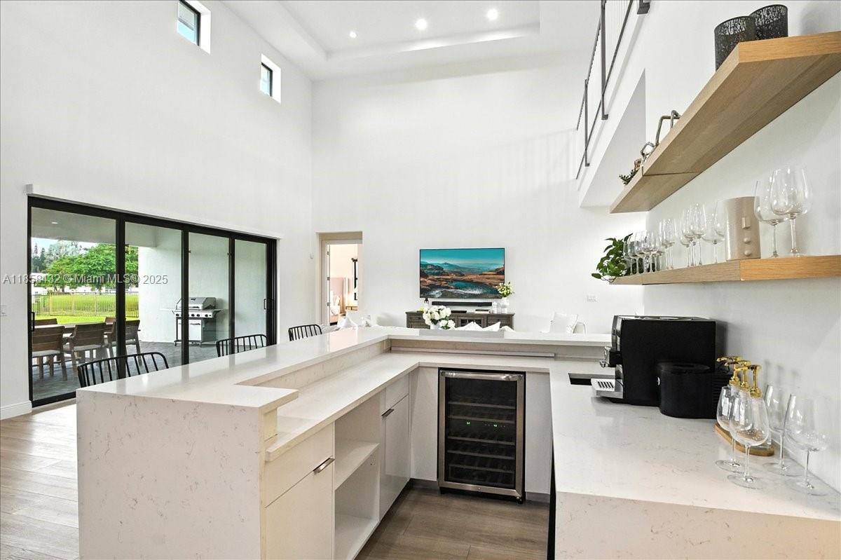 17819 Southwest 58th Street Southwest Ranches, FL 33331 - Photo 19 of 56 a kitchen with kitchen island a stove a sink and a refrigerator with wooden floor