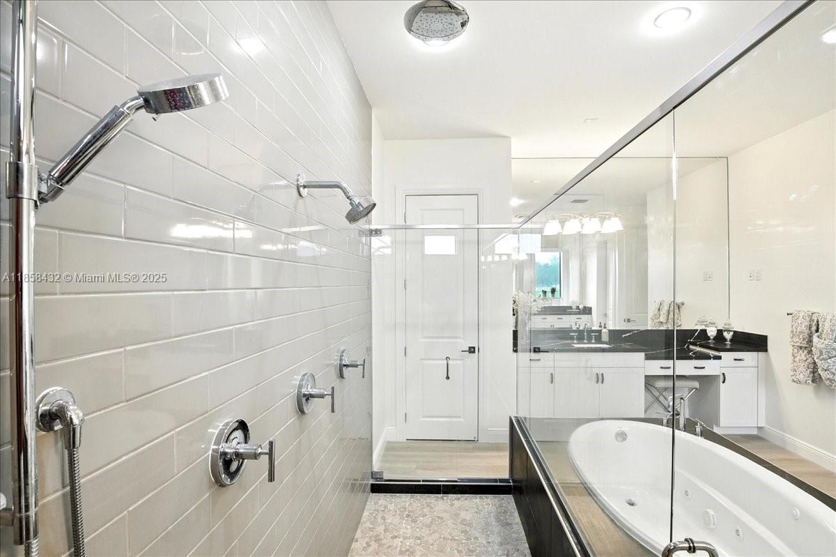 17819 Southwest 58th Street Southwest Ranches, FL 33331 - Photo 24 of 56 a bathroom with a tub a double vanity sink a mirror and shower