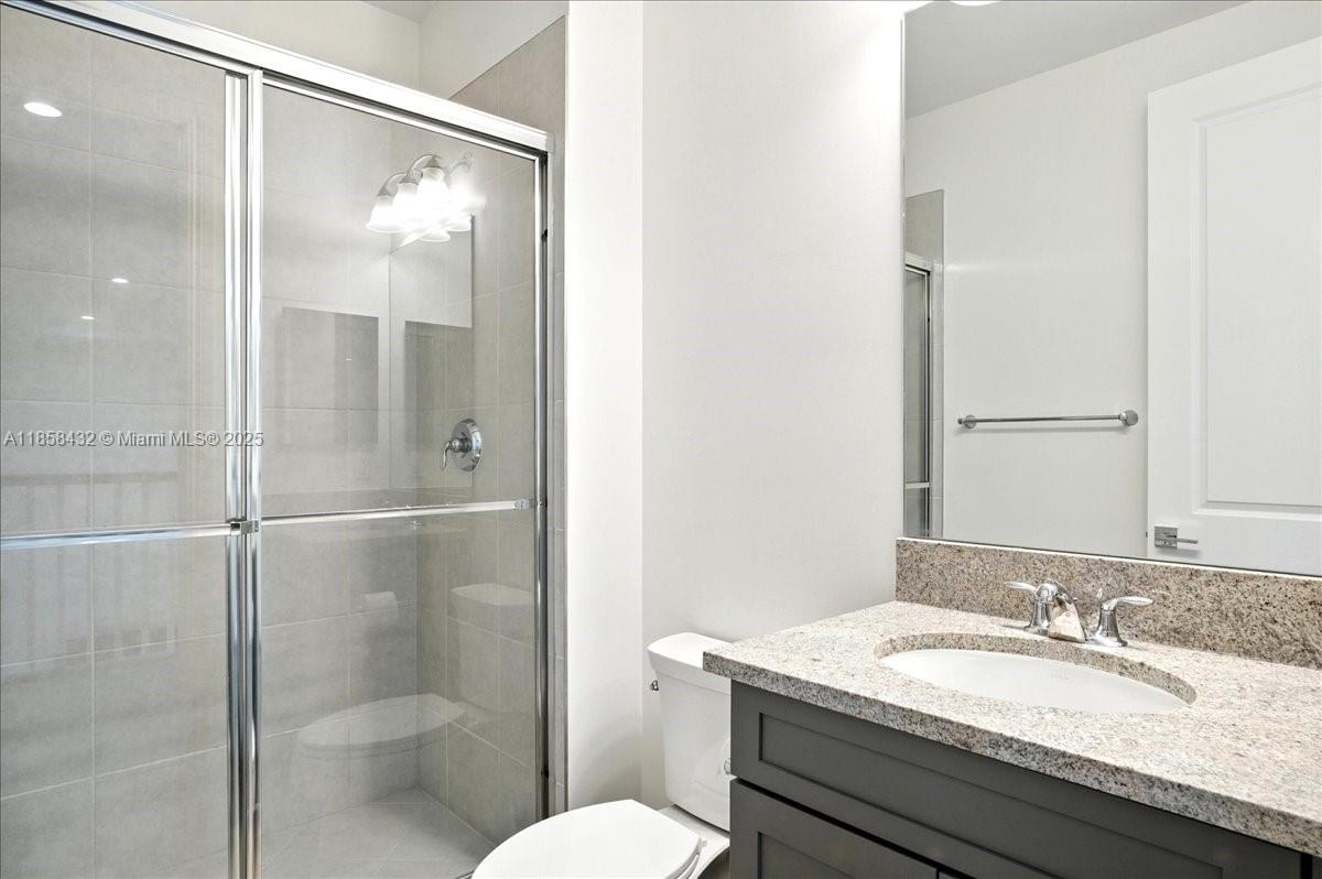 17819 Southwest 58th Street Southwest Ranches, FL 33331 - Photo 34 of 56 a bathroom with a granite countertop sink toilet and shower