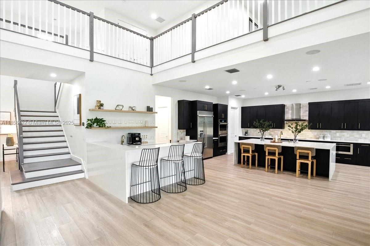 17819 Southwest 58th Street Southwest Ranches, FL 33331 - Photo 4 of 56 a kitchen with stainless steel appliances kitchen island granite countertop a refrigerator and a stove top oven