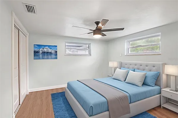 a bedroom with a large bed and a ceiling fan