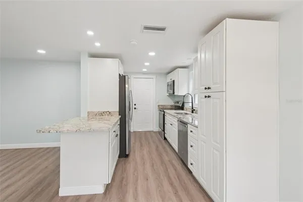 a kitchen with stainless steel appliances granite countertop a sink stove and refrigerator