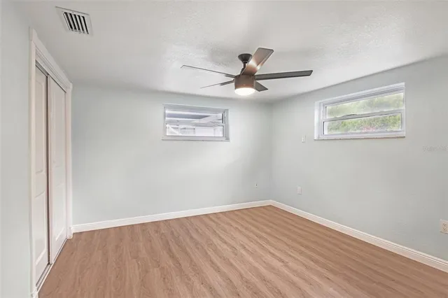 a view of empty room with wooden floor