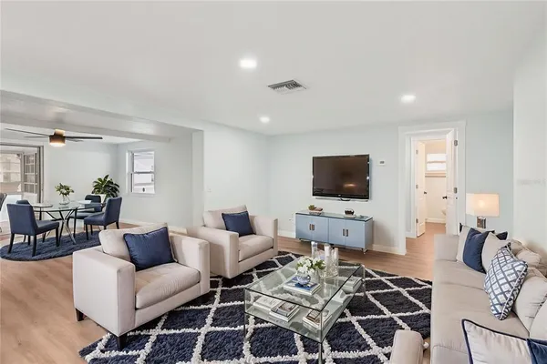 a living room with furniture a flat screen tv and a table