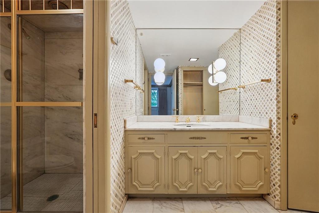 5048 Fifth Avenue, Unit 101 Pittsburgh, PA 15232 - Photo 19 of 24 a bathroom with a granite countertop sink a mirror and a shower