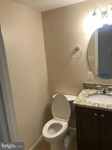 a bathroom with a granite countertop toilet and a mirror