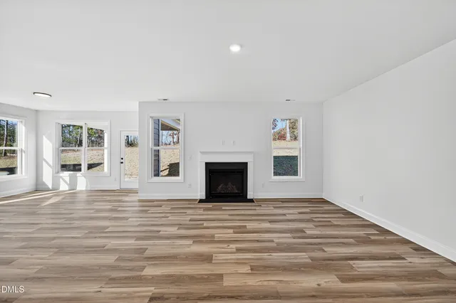 a view of an empty room with window and fireplace
