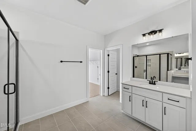 a bathroom with a double vanity sink a mirror and a shower