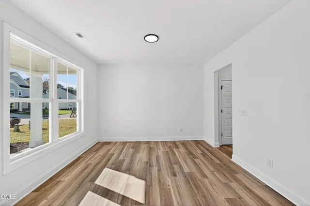 a view of a room with wooden floor and windows