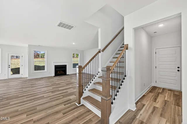 a view of a livingroom with wooden floor and stairs