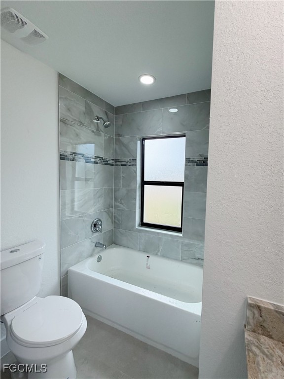 2800 46th Street Southwest Lehigh Acres, FL 33976 - Photo 12 of 15 a white toilet sitting next to a bath tub