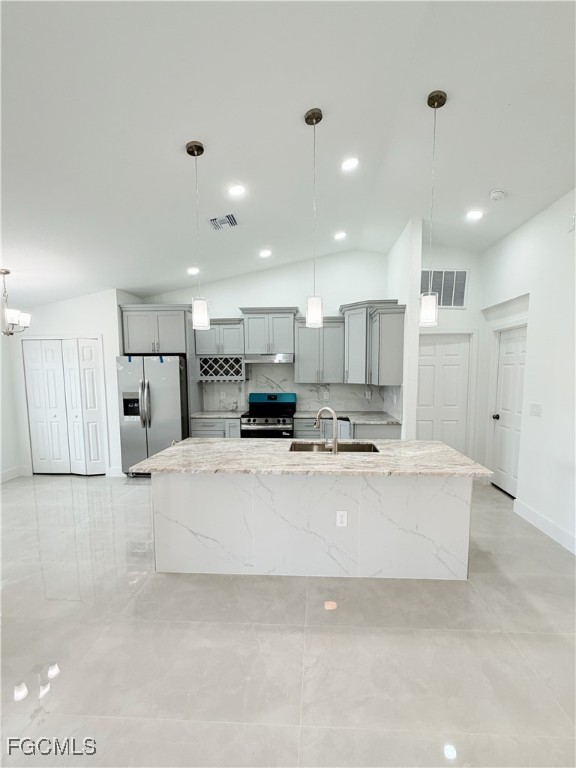 2800 46th Street Southwest Lehigh Acres, FL 33976 - Photo 6 of 15 a large white kitchen with kitchen island a sink a center island stainless steel appliances and a refrigerator