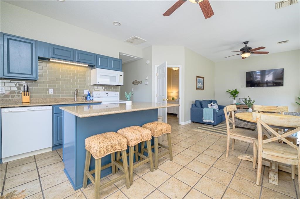 102 Ball Street Rockport, TX 78382 - Photo 19 of 40 a kitchen with a dining table chairs and a sink