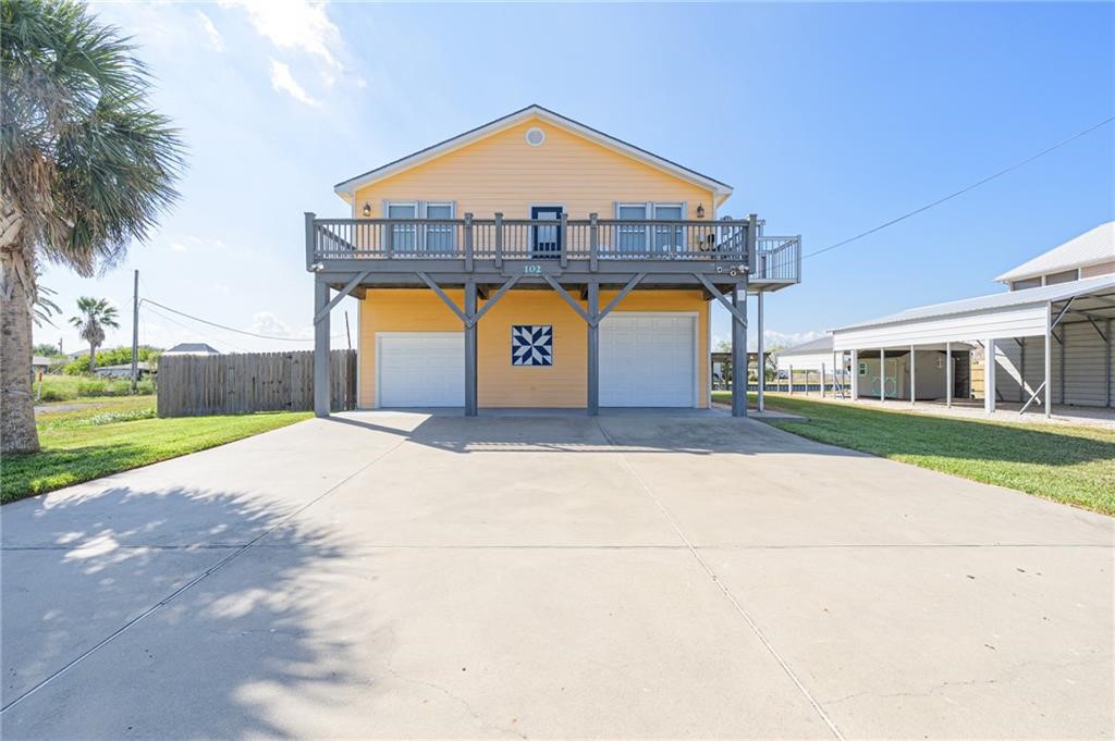 102 Ball Street Rockport, TX 78382 - Photo 3 of 40 a front view of a house with a yard and garage