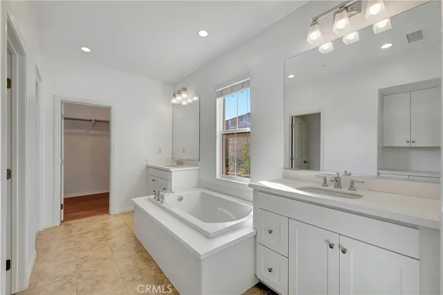 a bathroom with a sink double vanity granite and a bathtub