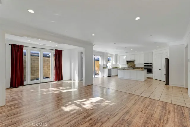 a view of large hall with wooden floor and a large window