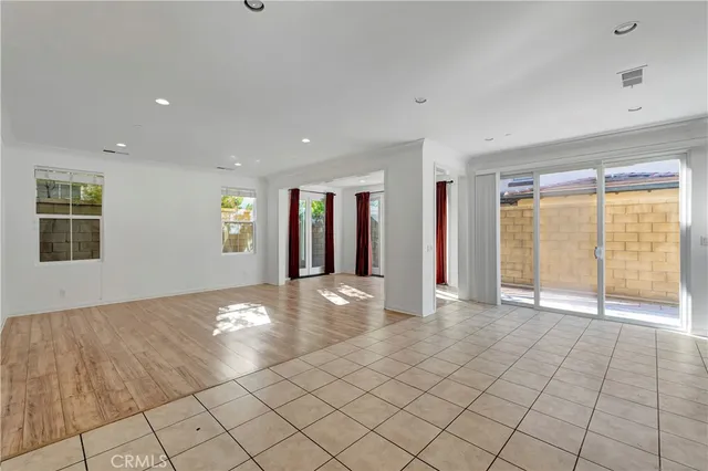 a view of an empty room with window and chandelier