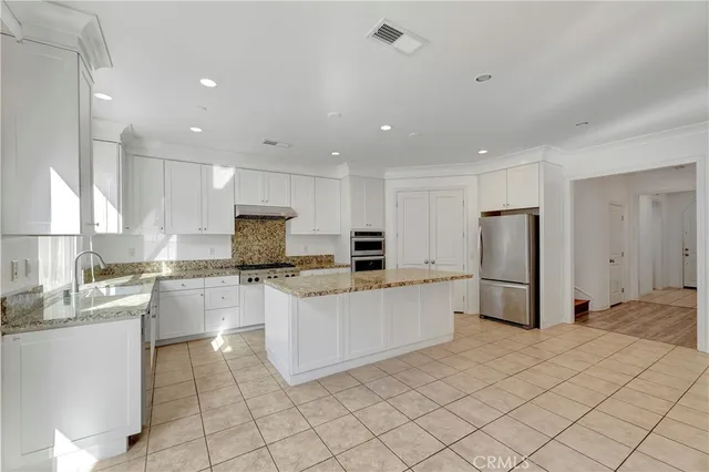a kitchen with stainless steel appliances a refrigerator sink and microwave