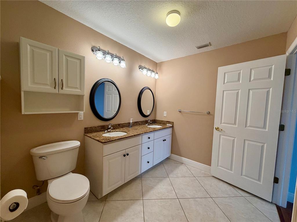 1020 2nd Avenue Northwest Largo, FL 33770 - Photo 20 of 37 a bathroom with a toilet sink vanity granite and a mirror