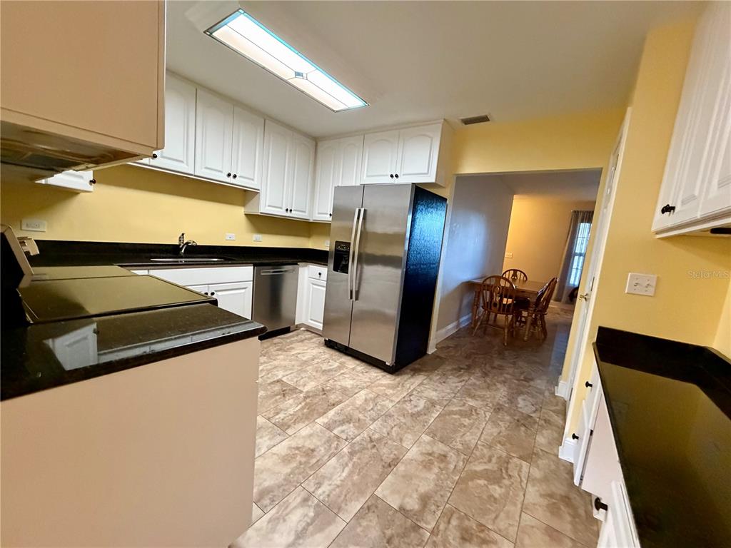 1020 2nd Avenue Northwest Largo, FL 33770 - Photo 23 of 37 a kitchen with stainless steel appliances a sink a stove a refrigerator and cabinets