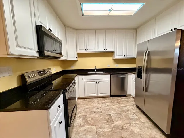 a kitchen with stainless steel appliances a stove a microwave and cabinets