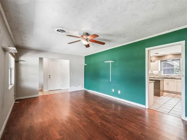 a view of a livingroom with wooden floor and a ceiling fan