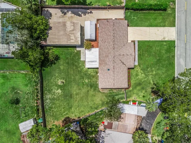 an aerial view of residential houses with outdoor space and trees