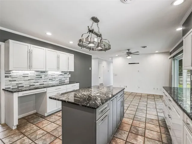 a kitchen with granite countertop stainless steel appliances a sink stove and cabinets
