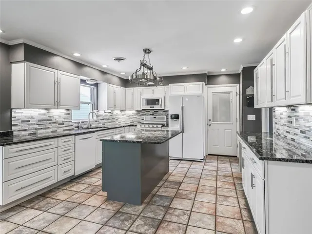 a kitchen with stainless steel appliances kitchen island granite countertop a sink and cabinets