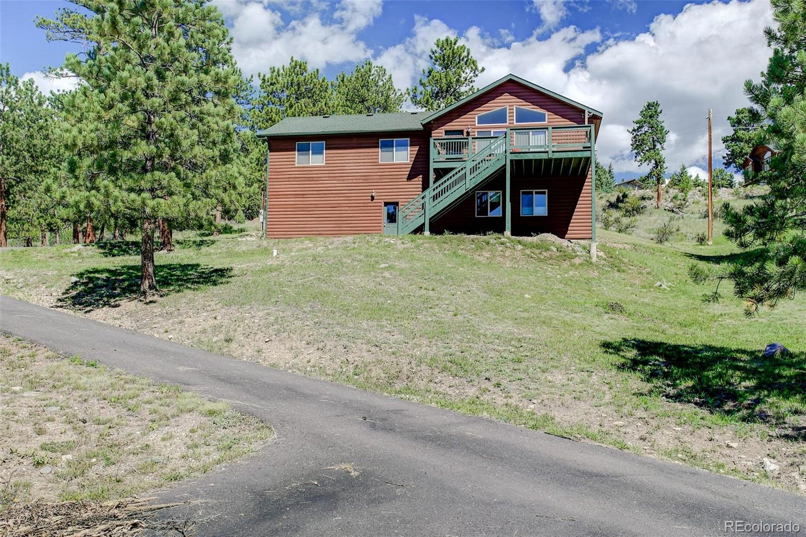 29 Pine Trail Bailey, CO 80421 - Photo 2 of 30 a front view of a house with a yard and garage