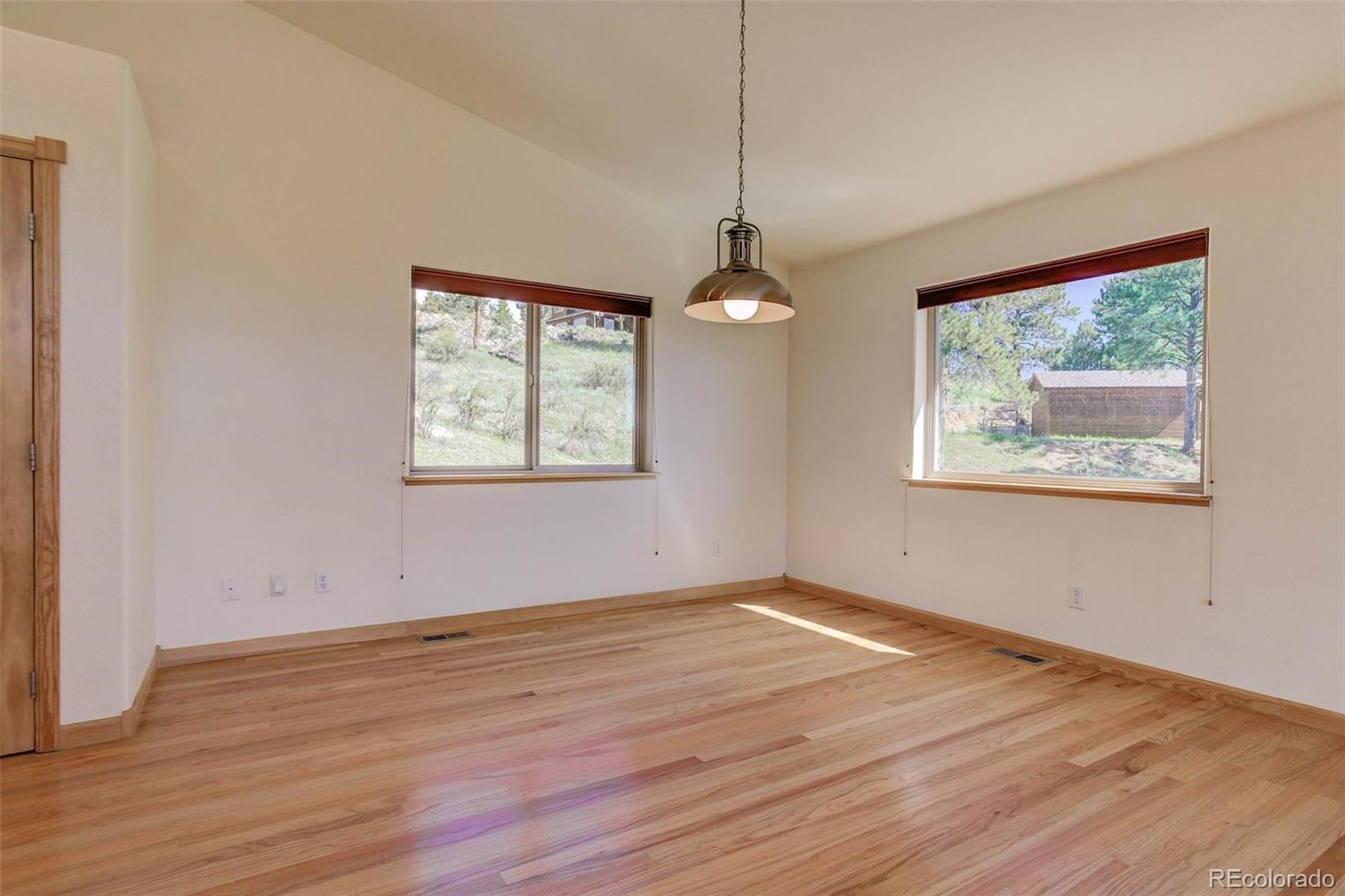 29 Pine Trail Bailey, CO 80421 - Photo 7 of 30 a view of an empty room with wooden floor and a window