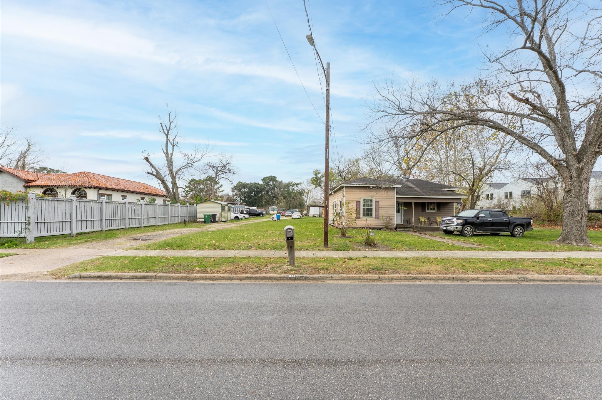 6415 Knox Street Houston, TX 77091 - Photo 1 of 12 a view of a house with a big yard and large trees