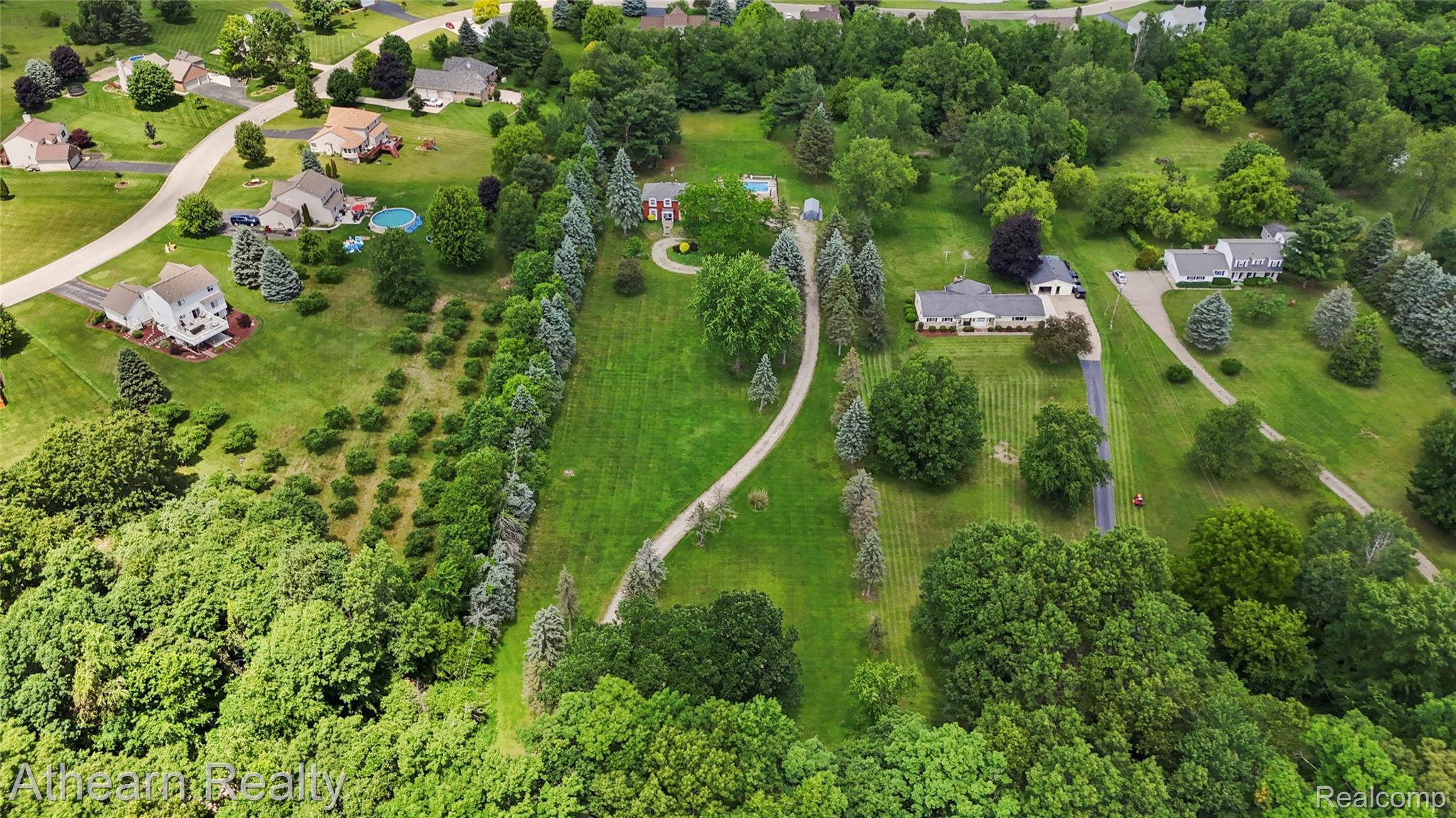 12427 Foley Road Fenton, MI 48430 - Photo 15 of 47 Expansive property featuring mature trees, paved driveways, a red brick residence, and a white residence
