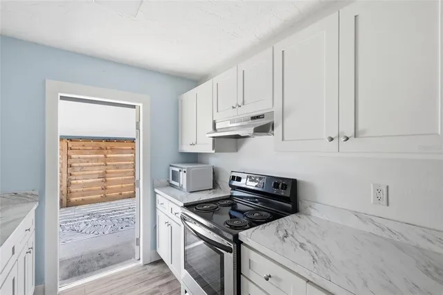 a kitchen with white cabinets and appliances