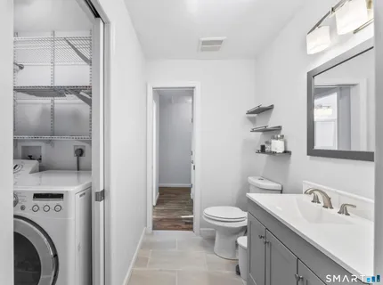 a bathroom with a toilet sink vanity and mirror