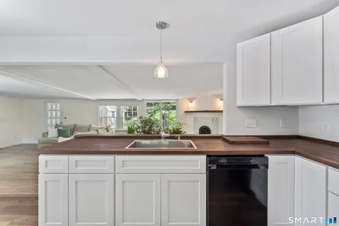 a kitchen with granite countertop a sink and white cabinets