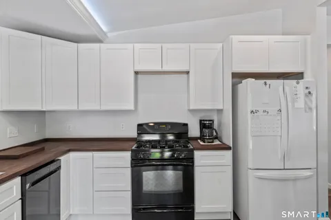a kitchen with stainless steel appliances granite countertop white cabinets and a stove