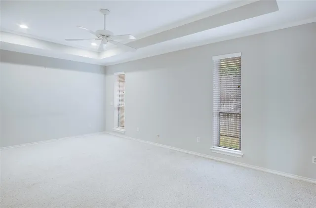 a view of a livingroom with a chandelier fan and windows