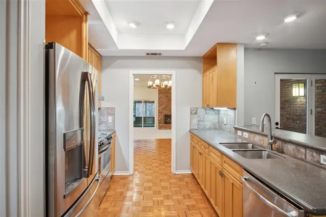 a kitchen with stainless steel appliances granite countertop a refrigerator and a sink