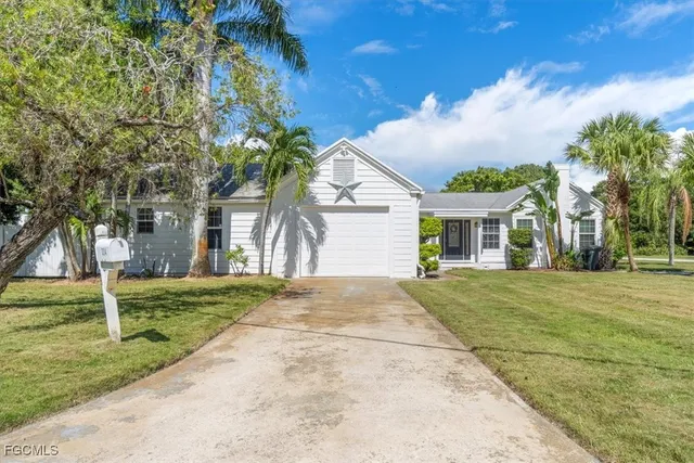 a front view of a house with a garden and trees