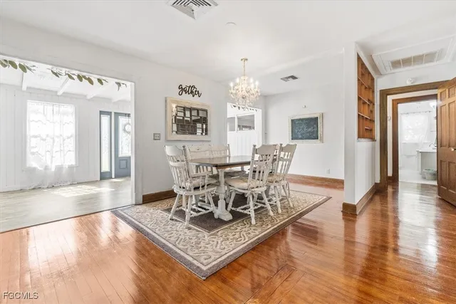 a living room with furniture and a dining table with wooden floor