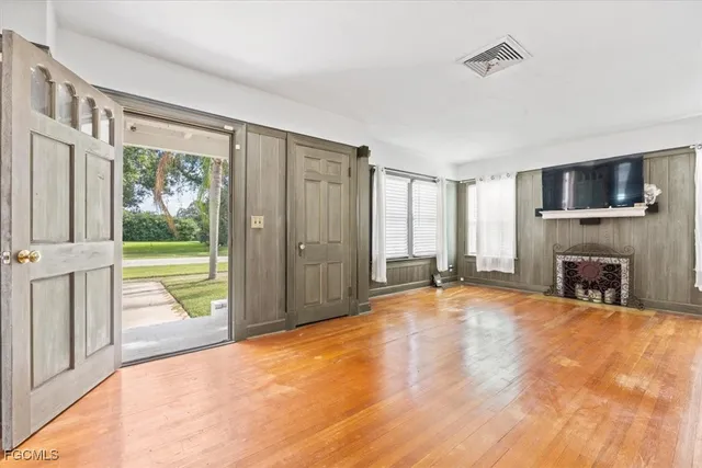 a view of an empty room with a fireplace and a window