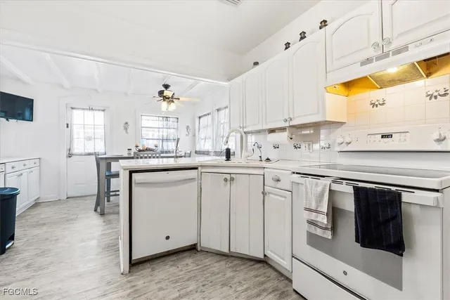 a kitchen with granite countertop white cabinets and white appliances