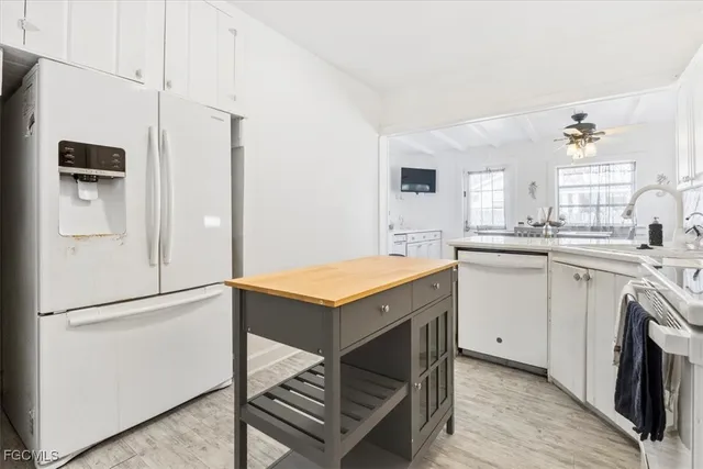 a kitchen with white cabinets and white appliances