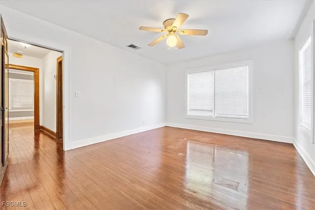 an empty room with wooden floor and window