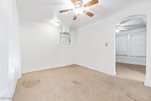 an empty room with chandelier fan