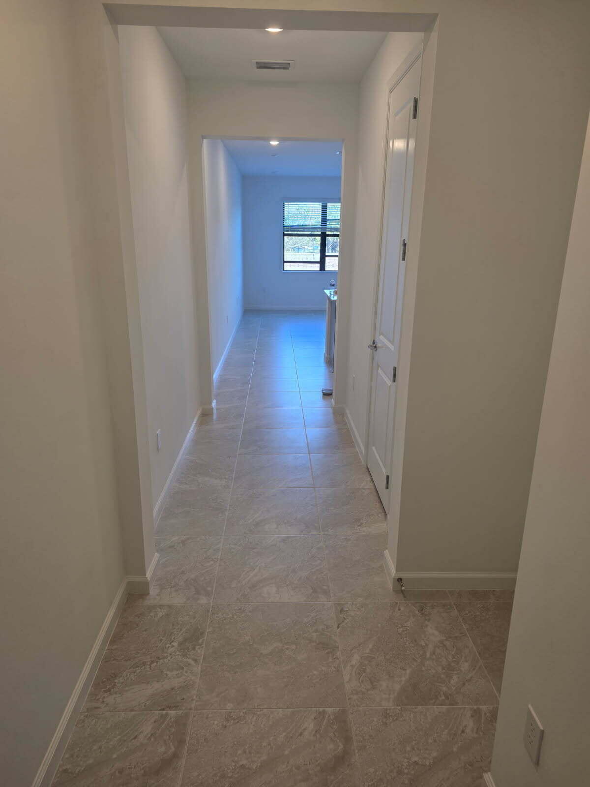 7783 Southwest Bentley Lane Stuart, FL 34997 - Photo 2 of 34 a view of a hallway with wooden floor and a living room